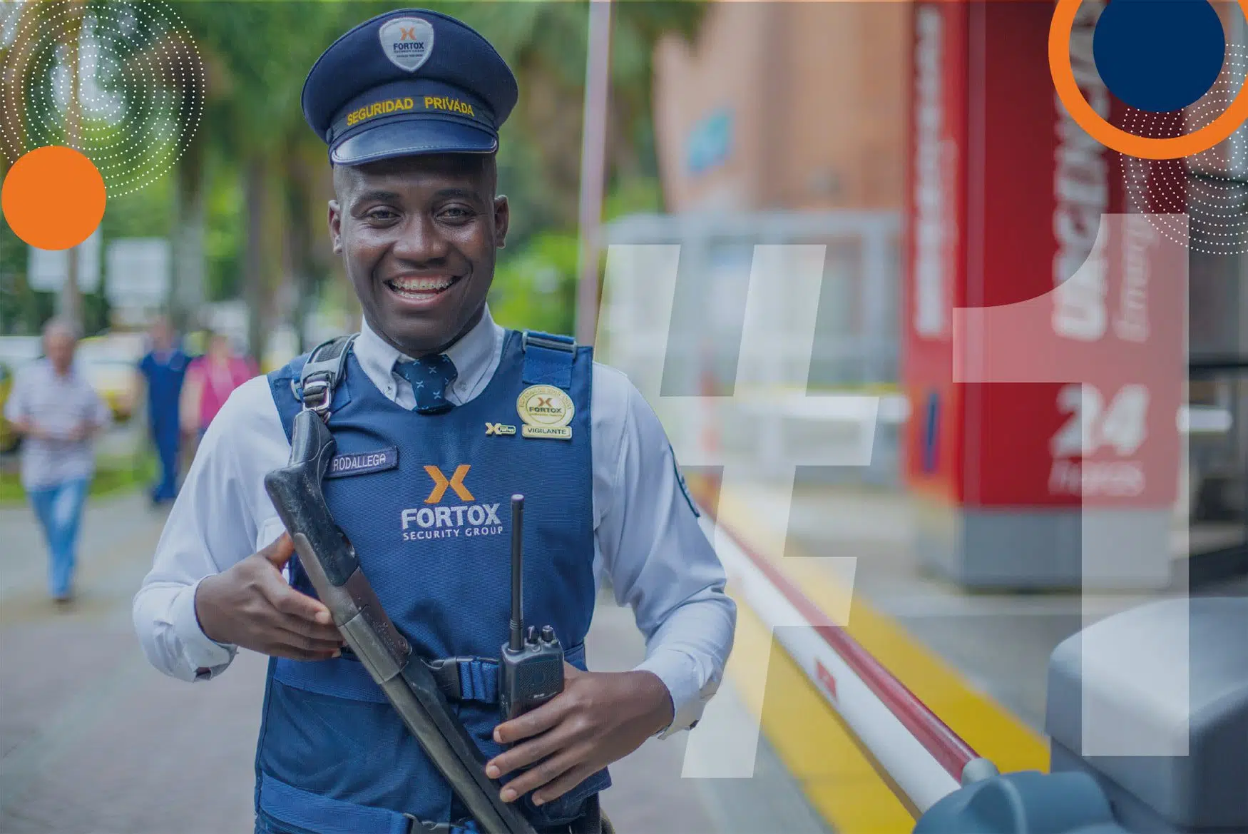 Guardia de seguridad privada Fortox con uniforme y radio, junto a una barrera en zona urbana con edificios y transeúntes. - Fortox Security