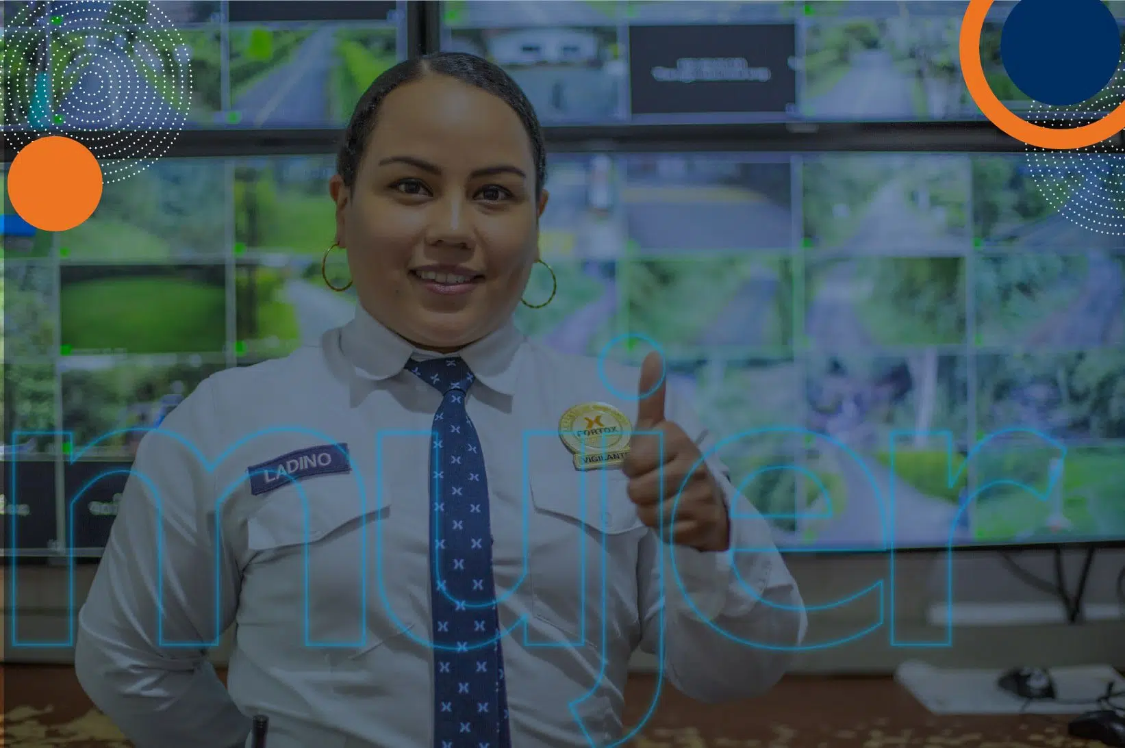 Mujer de Fortox con uniforme de seguridad privada sonríe, con el pulgar hacia arriba y hay monitores de vigilancia al fondo. - Fortox Security