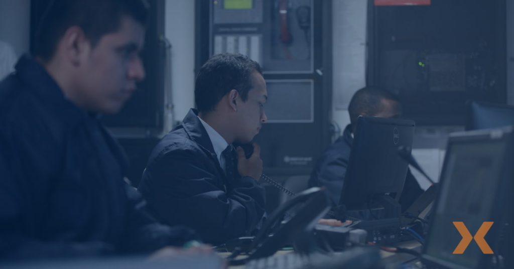 Personal de Fortox brinda servicios de seguridad privada y vigilancia frente a monitores en una sala de control empresarial. - Fortox Security