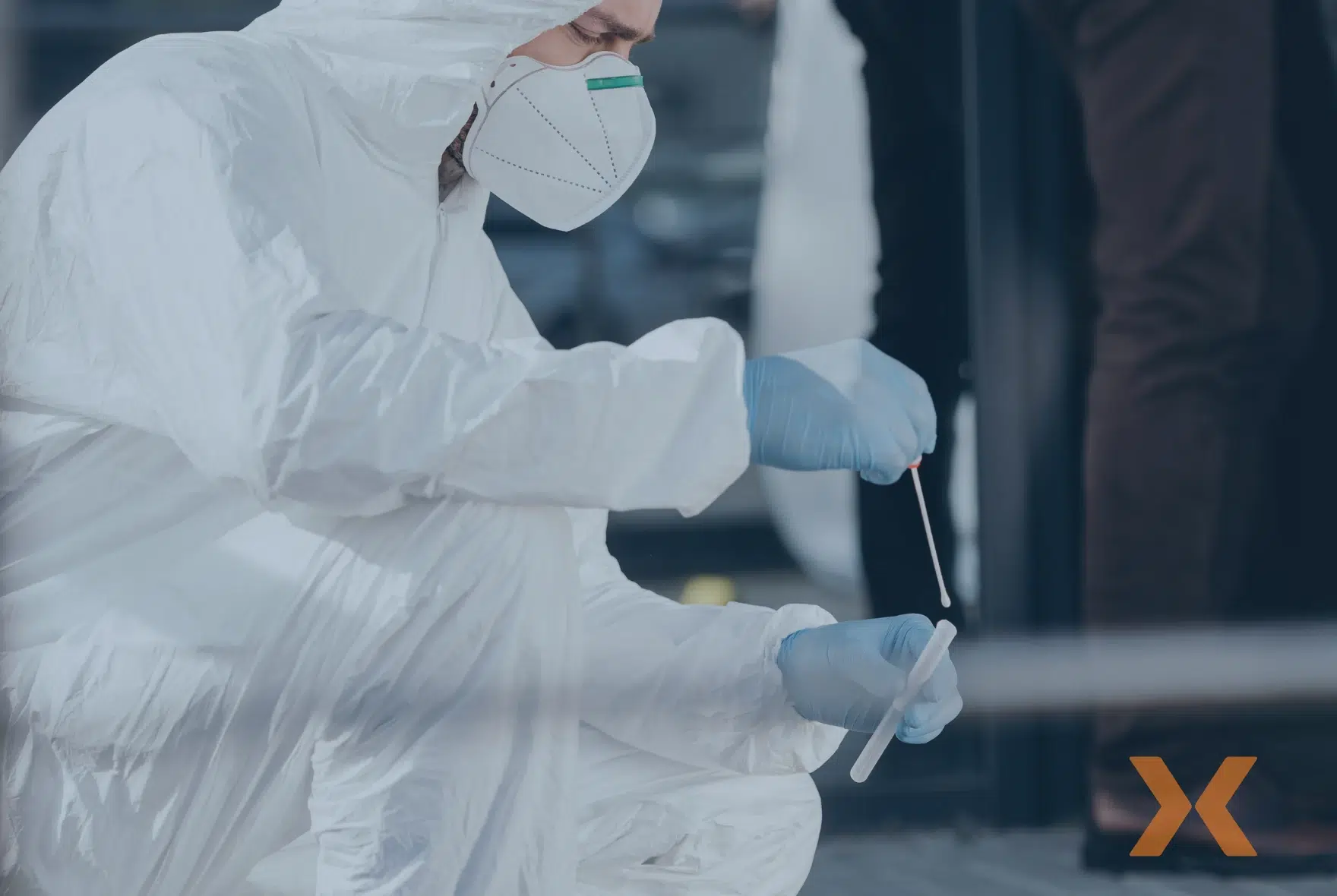 Persona con traje de protección y mascarilla toma muestras para peritajes especializados en un entorno controlado de seguridad privada. - Fortox Security