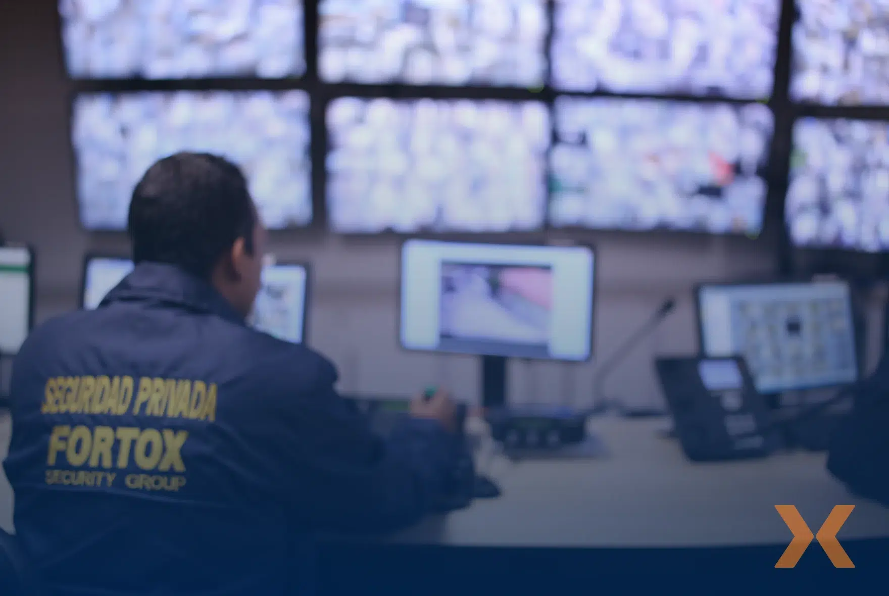 Guardia de seguridad privada de Fortox monitorea pantallas en sala de control para vigilancia y protección empresarial. - Fortox Security