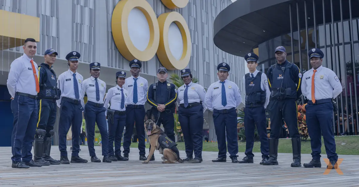 Personal de seguridad privada y vigilancia con perro frente a edificio moderno, representando servicios de seguridad empresarial. - Fortox